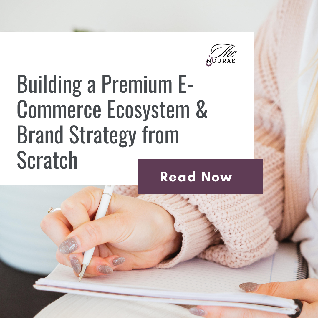 Article cover graphic for The Nourae titled "Building a Premium E-Commerce Ecosystem & Brand Strategy from Scratch," showing a close-up of a hand writing in a notebook.